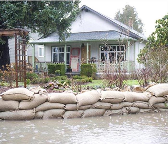 This picture shows sand bags stacked in front of a home protecting it from floodwaters.