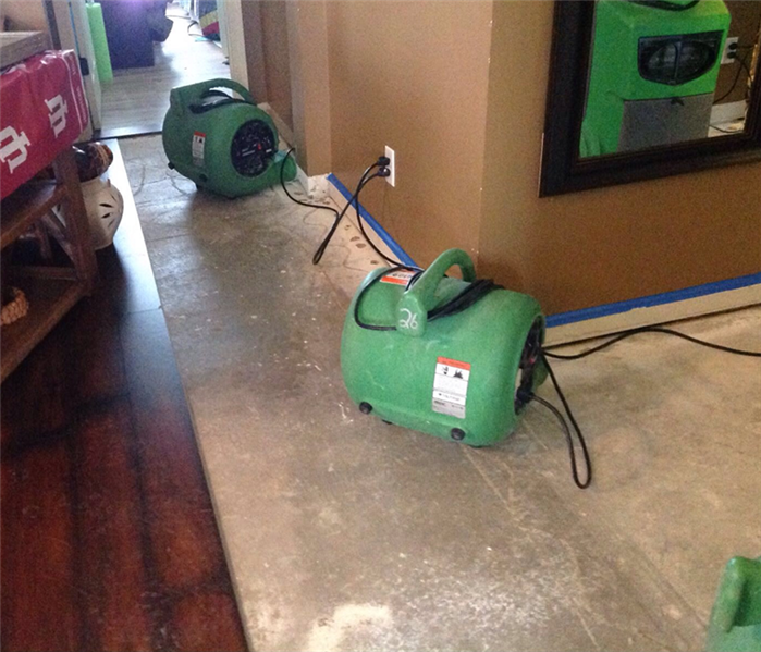 This picture shows some air movers drying the wall after a water damage in a hallway.