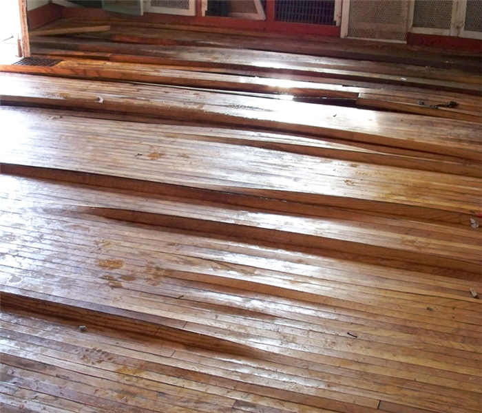 This picture shows the damage to laminate flooring after a water damage.