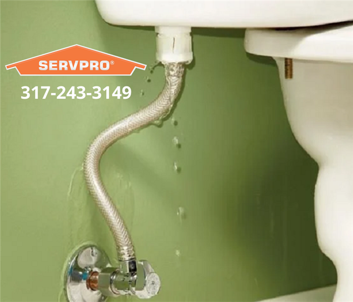 This picture shows a leaking toilet with the SERVPRO logo and our office phone number. 
